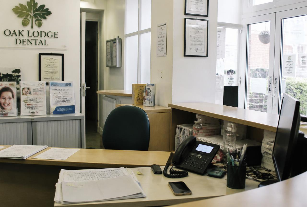 A dental practice reception desk with the phone ringing and nobody there to answer